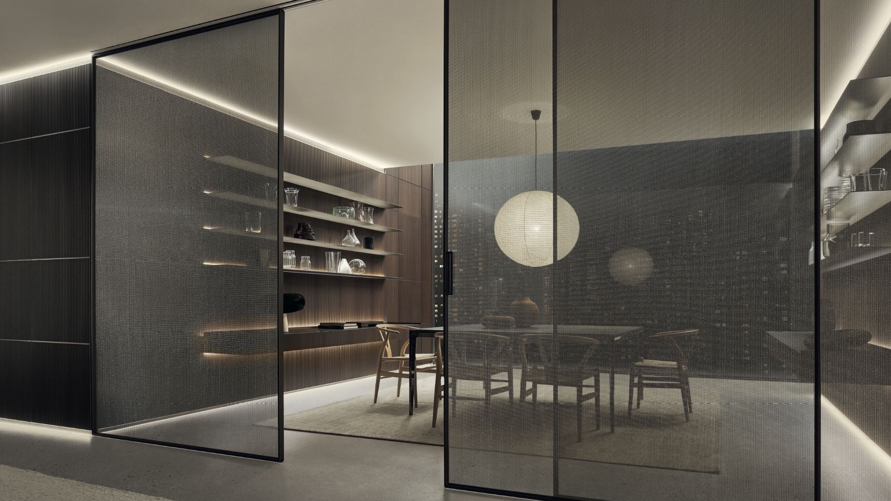 Rimadesio Velaria schuifdeur in rete glas met aluminium profiel, toegepast als transparante ruimtescheiding binnen een architectonisch interieur